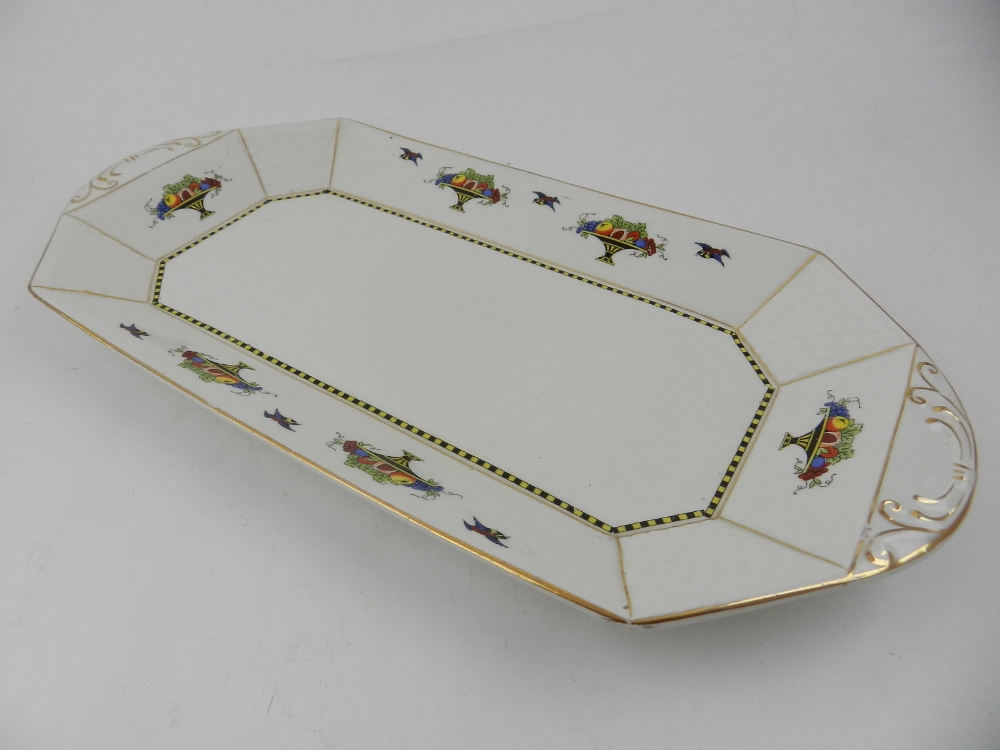 A Burslem octagonal serving tray dish, decorated with fruit basket within gilt panelled borders,