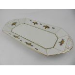 A Burslem octagonal serving tray dish, decorated with fruit basket within gilt panelled borders,
