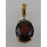 A yellow metal, garnet, and diamond pendant, the oval cut garnet mounted with four small diamonds,