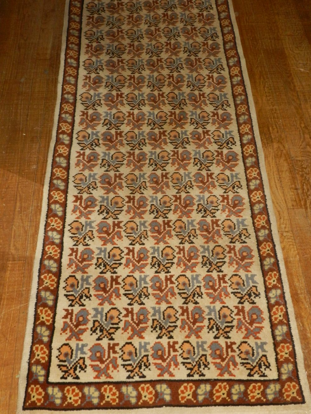 A cream ground Turkish runner, decorated with stylised flowers to centre, fringed. L.457cm W.