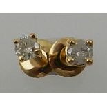 A pair of yellow metal and solitaire diamond stud earrings, each stone approx. 0.2 carats.