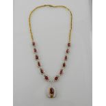 A fine yellow gold, diamond and ruby cluster necklace, the drop pendant flanked by clusters,