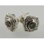 A pair of diamond ear studs, in white metal frames, 1.8g.