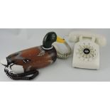 A telephone modelled in the form of a wooden duck decoy, together with another telephone,