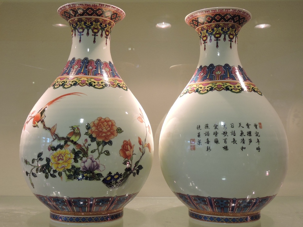 A pair of modern Chinese porcelain vases, decorated with birds among peony.  Height 25cm.