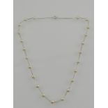 A 14 carat white gold and pearl necklace, the pearls spaced along the fine curb link chain.