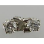 A pair of white metal and solitaire diamond ear studs, the stones of approx. 0.25 carats each.