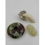 A white metal mounted tooth pendant, together with a jade carving and one other jadeite pendant.