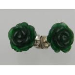 A pair of carved jade and white metal flower head ear studs.