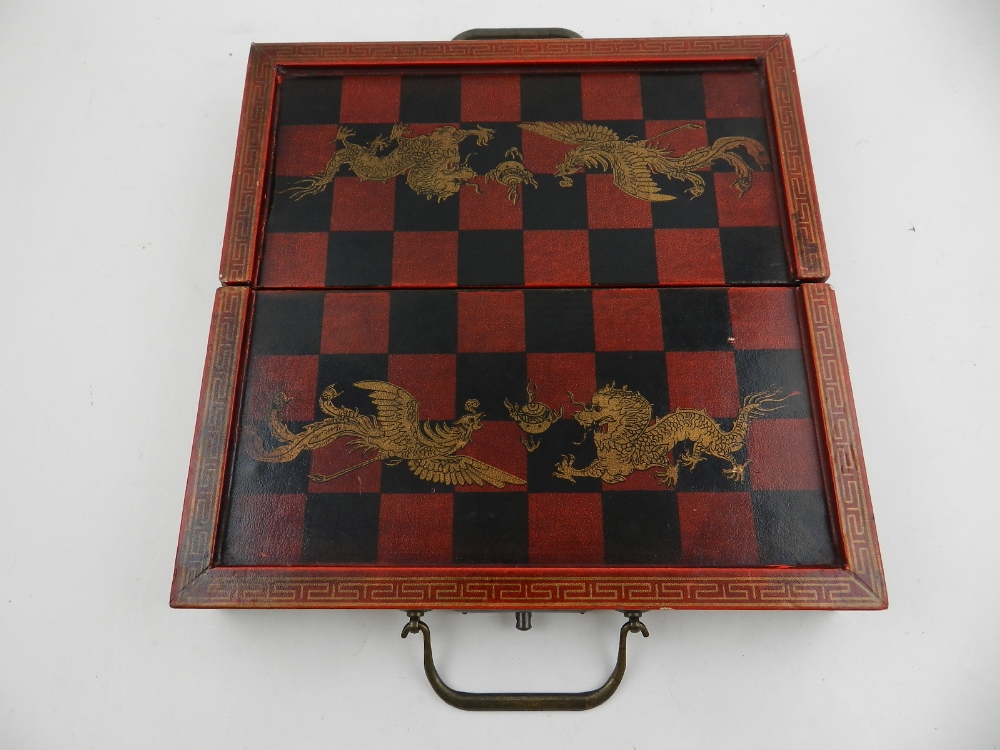A Chinese red lacquered chess set, decorated with gilt dragons, having painted wooden pieces. H. - Image 3 of 3