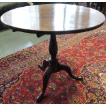 A late George III mahogany tripod table, the circular top above a turned baluster support, D. 77cm.
