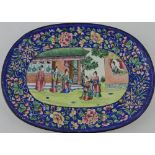 A late 19th century enamelled dish, the centre decorated with figures beside buildings,