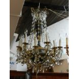 An Empire style bronze 12 branch chandelier, decorated with glass droplets.