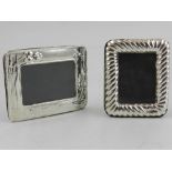 Two small silver easel-backed photograph frames.