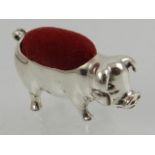 A novelty miniature pin cushion in the form of a pig, with red velvet cushion.