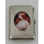 An early 20th century silver cigarette case, bearing later plaque depicting an auburn-haired woman.