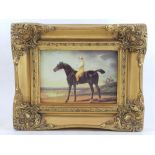 An image of a horse and rider, in a gilt frame.