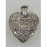 A sterling silver miniature perfume bottle in the shape of a heart.