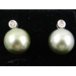 A pair of white gold, South Sea pearl, and diamond stud earrings.