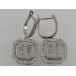A pair of white metal and cubic zirconia set drop earrings.