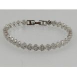 A silver and cubic zirconia set articulated tennis bracelet.