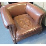 An early 20th century leather upholstered club chair, on short turned legs,