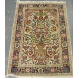 A small Kahmir  ivory ground mat woven with a central vase of flowers within a triple floral border,