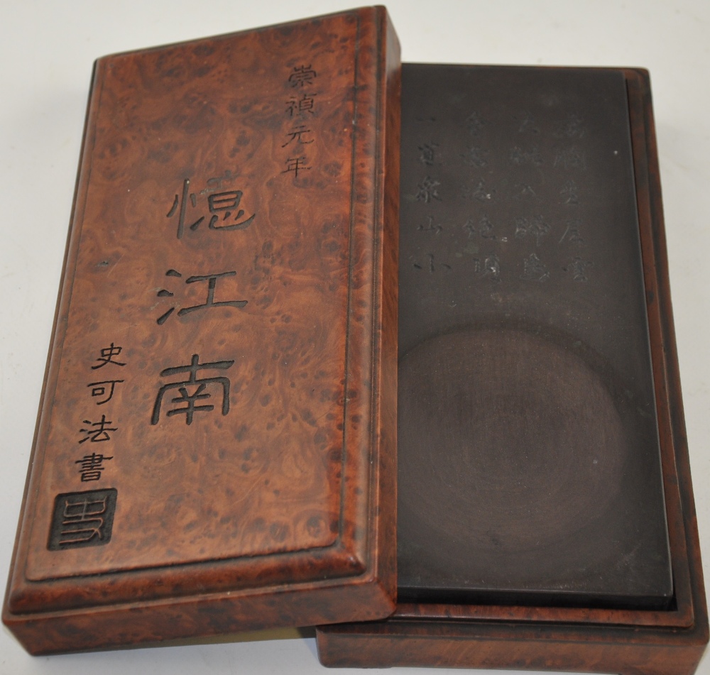 A Chinese rectangular ink stone, within a hardwood effect box, W. 25cm.