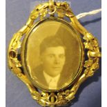 A gilt metal brooch, floral decorated with a central oval reserve for a photograph, H. 5cm.