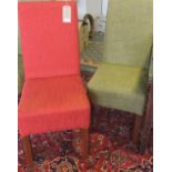 A pair of contemporary upholstered dining chairs, covered in a red hop-sack material,