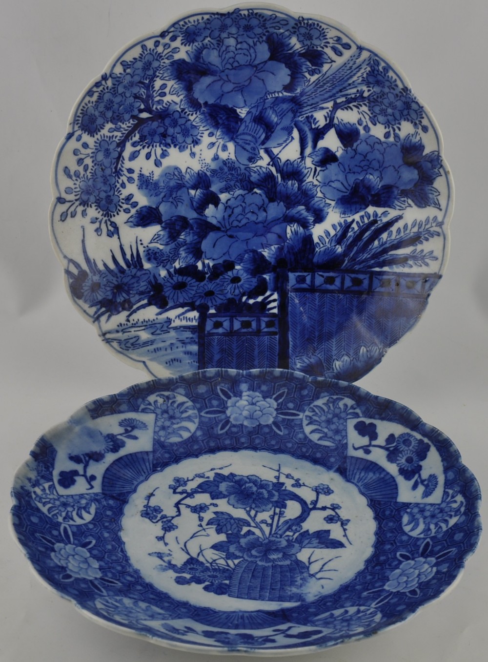 A 20th century blue and white charger, with ascalloped ring and decorated with a garden scene, D.