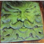 A painted reconstituted stone garden wall applique depicting the green man