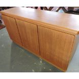 A Scandanavian teak sideboard in the style of Benny Lindon enclosed by three doors,