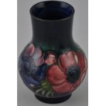 A Moorcroft pottery baluster vase, decorated with a band of Anemone on a mottled blue body,