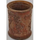 A Chinese bamboo brush pot, of cylindrical form and carved with figure beneath trees, H. 18cm.