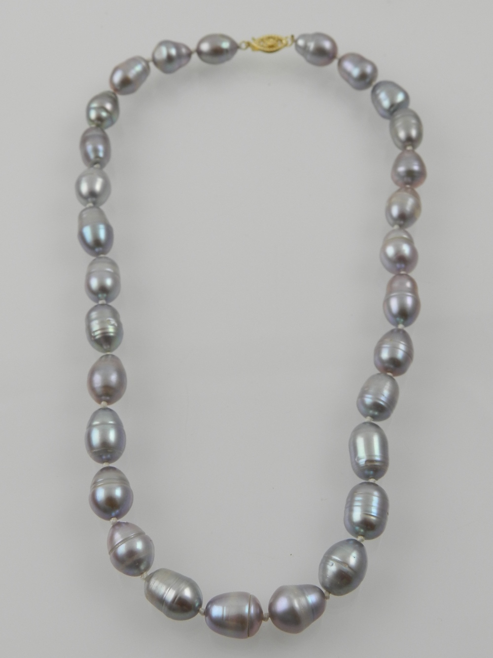 A strand of Tahitian pearls, of grey-silver colour, with a 14 carat yellow gold clasp.