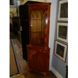 A 19th century style yew wood corner cabinet, single cupboard door below astragal glazed door. H: