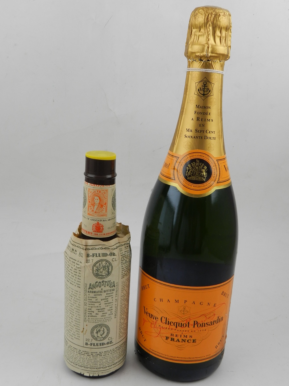 A bottle of champagne, together with a bottle of bitters.