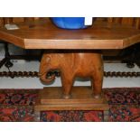 A 20th century teak hexagonal coffee table, the base in the form of an elephant.