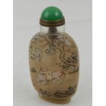 A Chinese peking glass snuff bottle, painted with dogs under cherry blossom, H.9.