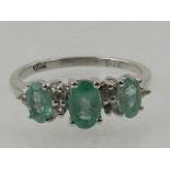 A 9 carat white gold, diamond, and emerald ring,