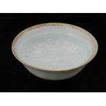 A Chinese celadon porcelain tea bowl, having raised foliate decoration to centre, D.