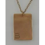 A 9 carat yellow gold tag pendant, with the initial 'B' to lower left,