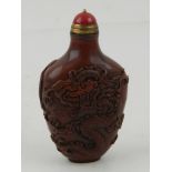 A Chinese hard stone snuff bottle, having raised decoration of dragons chasing pearl, H.