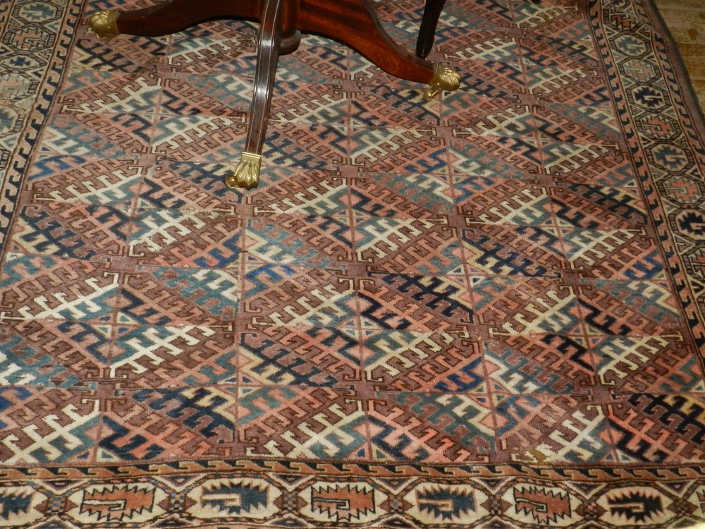 A red ground Turkoman carpet, having multi diamond shaped medallions to centre within many borders,