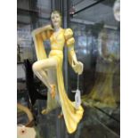 An Art Deco pottery figurine modelled as an elegant lady in a flowing yellow/orange glazed gown,