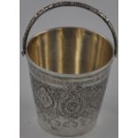 An early 20th century Iranian silver miniature pail with floral scroll engraving and cast swing