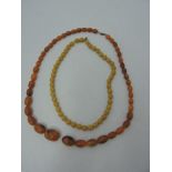 A sting of graduated oval shaped yellow beads, together with another,