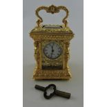 A rococo style miniature carriage clock, the case with caryatid supports and foliate panels, H. 9cm.