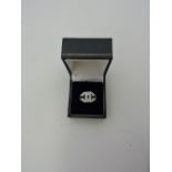 A cubic zirconia dress ring formed as a revered double C, 6.2g.